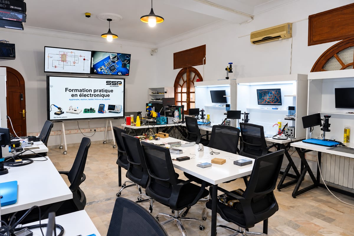 Atelier électronique : postes techniques équipés de microscopes, écrans et instruments de mesure