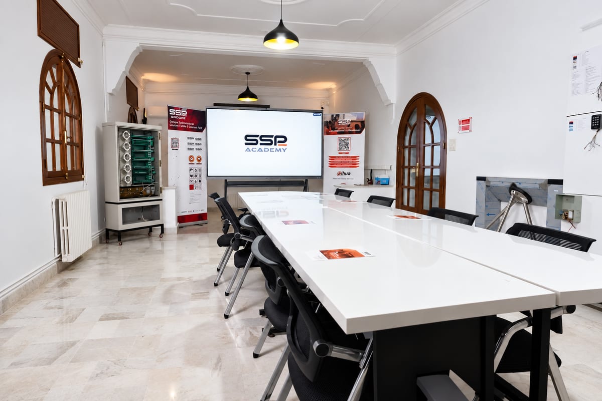 Salle polyvalente SSP Academy : grande table, écran interactif de 98 pouces et maquettes